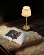 kdg gold cordless portable led table lamp, beige on a desk or shelf