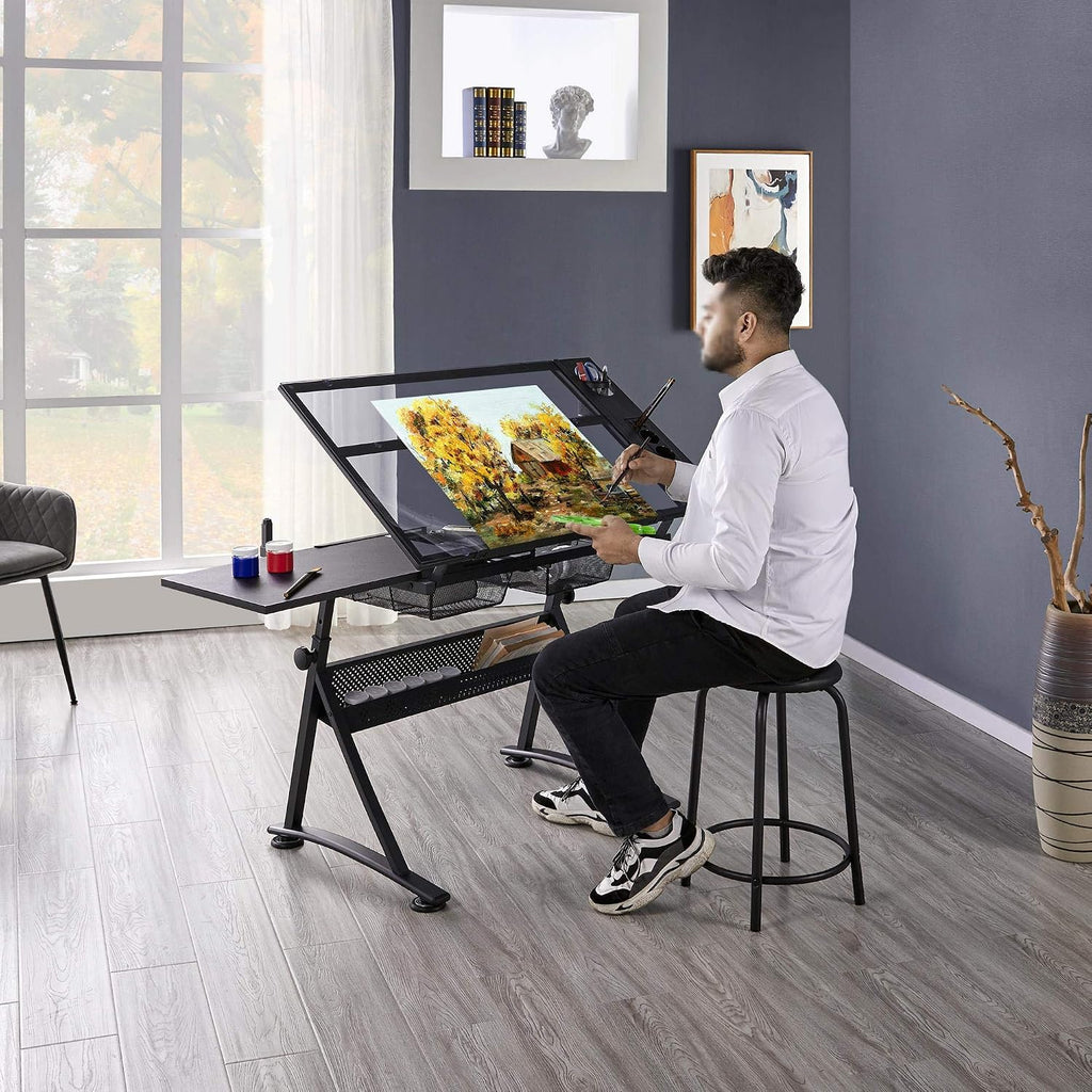 Yaheetech Adjustable Drafting Table & Stool, Tilting Glass Art Desk, Black | Tempered glass top tilts 0-40 degrees for drawing or tracing on a sturdy iron frame, with 2 mesh drawers for craft supplies.